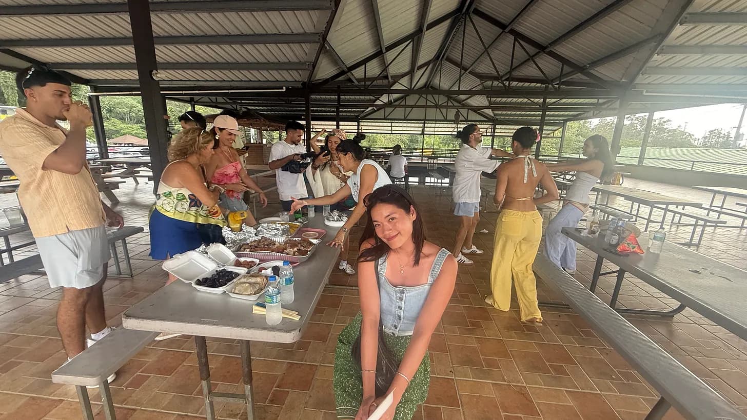 Friends gathering around picnic tables during a chinchorreo in Guavate.
